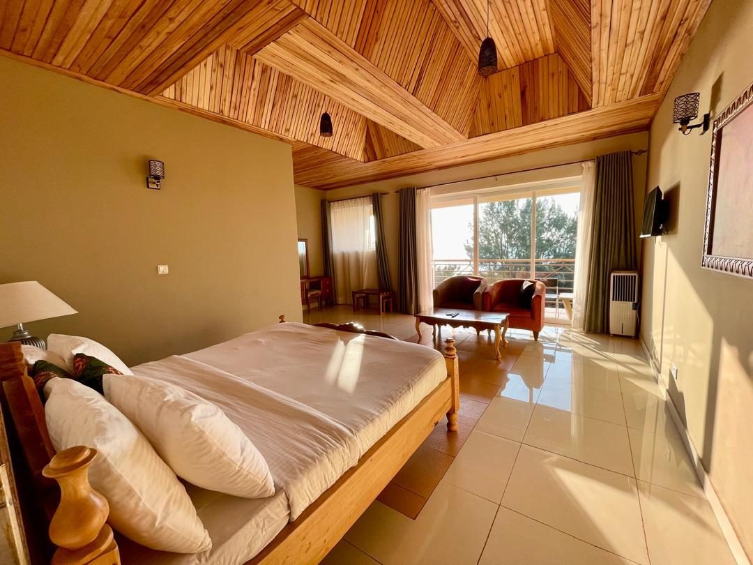 Superior Room bed, timber ceiling, and sitting area